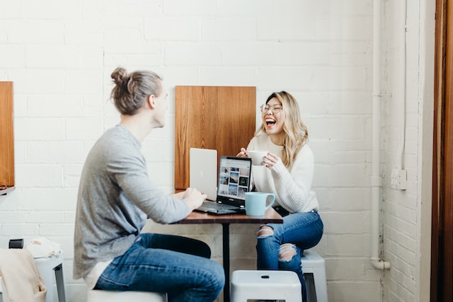 Two people smiling and talking at a table